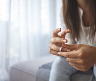 Unhappy woman holding wedding ring close up